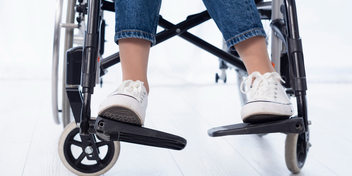 foto di sedia gambe di una persona su una sedia a rotelle