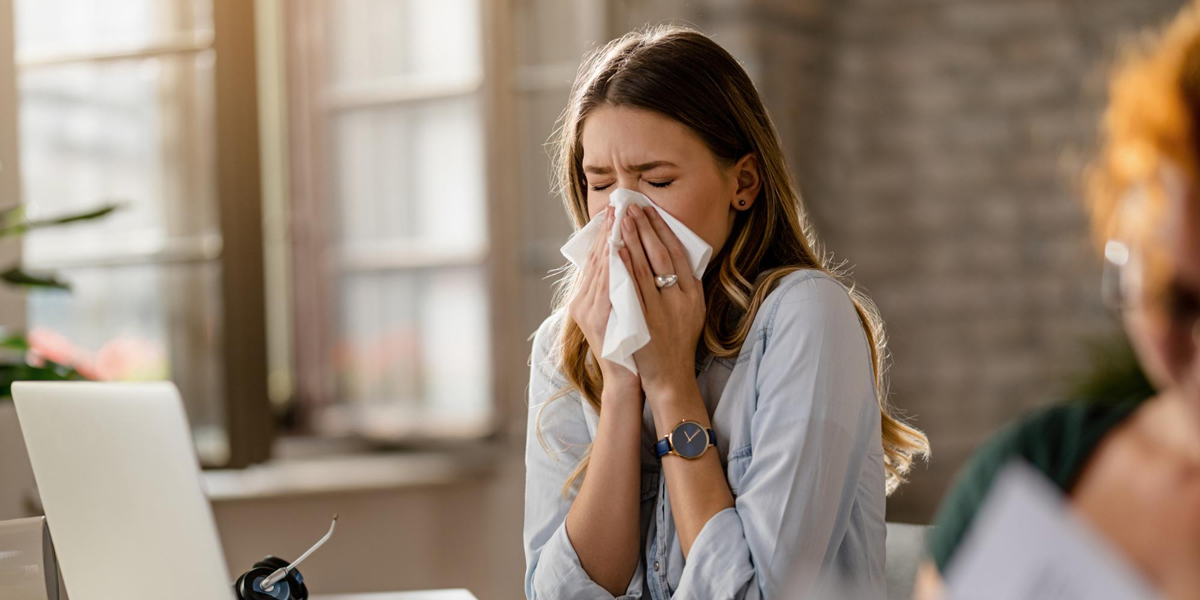 donna che si soffia il naso affetta da influenza stagionale